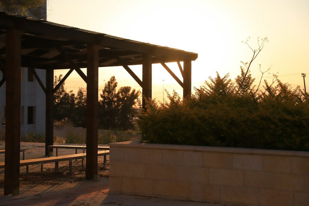 Wooden pergola with benches at sunset