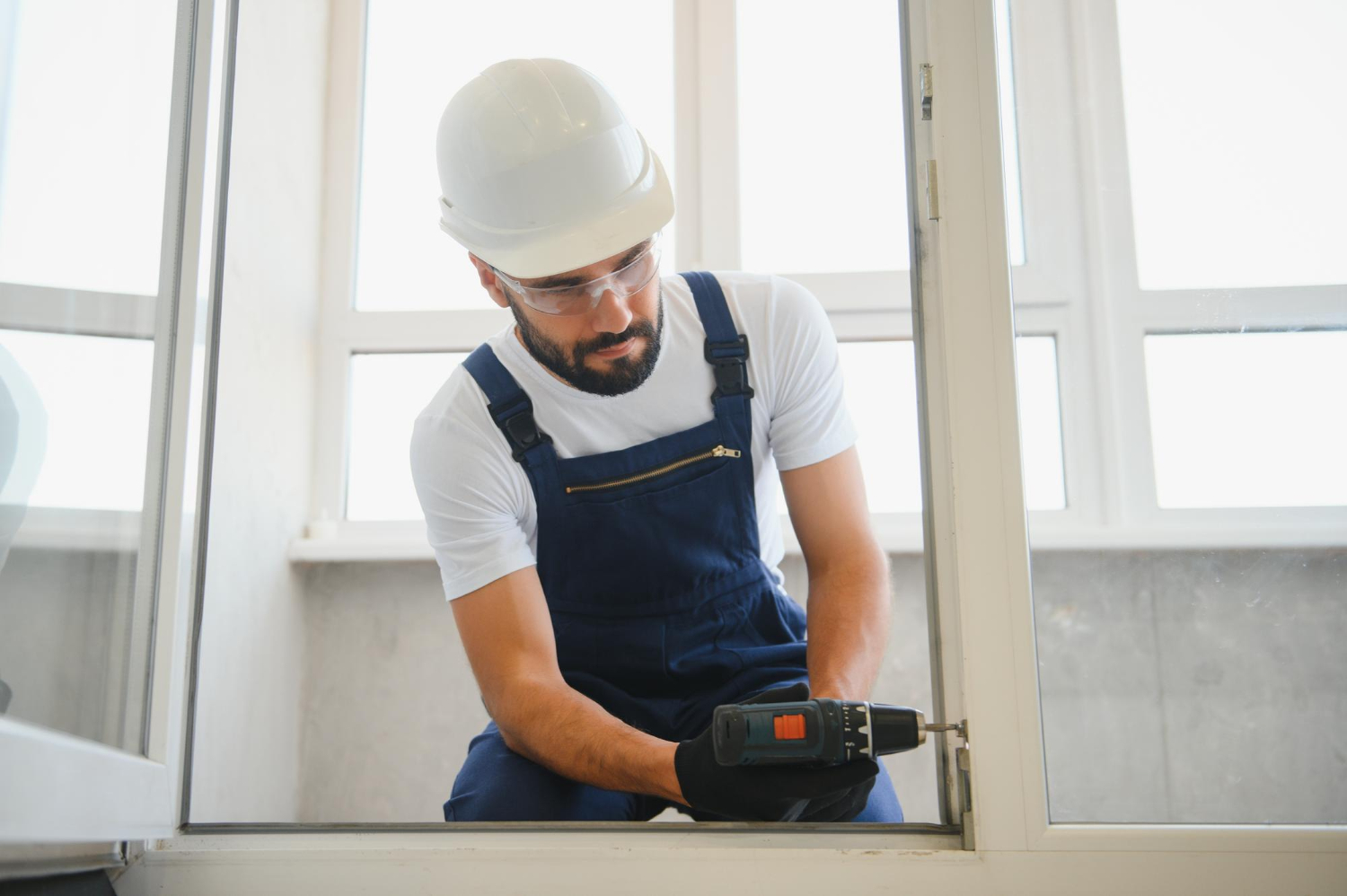 un homme en tenue professionnelle installe de nouvelles fenetres